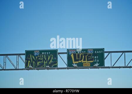 Graffiti on highway signs in Oakland, California Stock Photo