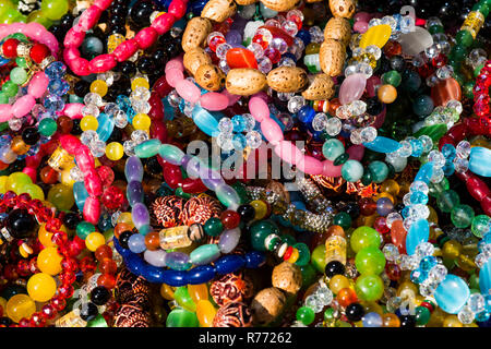 Colourful, inexpensive costume jewelry in a bin at the market. Stock Photo