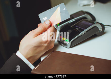 man in a jacket pays dinner in a restaurant contactless payment Stock Photo