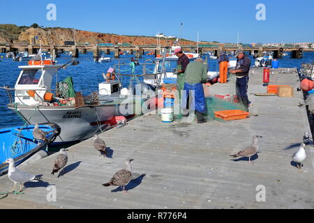SAGRES, PORTUGAL - NOVEMBER 12, 2018: Fishermen working on fishing nets at the fishing harbor Stock Photo