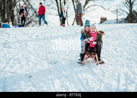 Two Girls Sledding Down the Hill Stock Photo