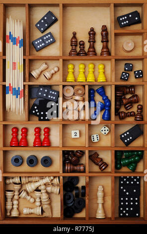 Wooden figures of board games, gaming pieces, dice, dominoes, Mikado sticks, games collection in a letter case Stock Photo