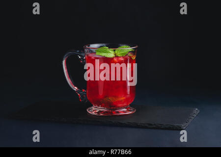 Fruit punch in a glass cup on a dark background with copy space for a menu. Strawberry, raspberry or cranberry winter drink Stock Photo