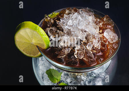 Espresso, mint and lime cocktail in a modern glass bowl. Coffee cold brew concept. Dark background with copy space for a menu. Stock Photo