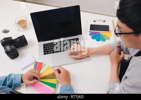Two photographers with camera and laptop computer working in office Stock Photo