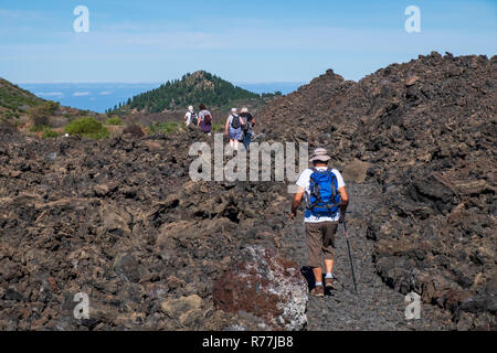 Walking group on a path through the Chinyero lava field, scene of the 1909 eruption on Tenerife, Canary Islands, Spain Stock Photo