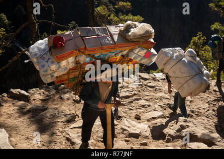Nepal, Namche Bazar, heavily laden porter carrying goods up to Namche Stock Photo