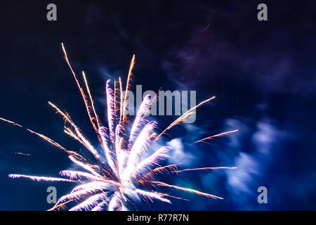 Bright festive fireworks against the background of the blue night sky Stock Photo