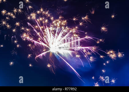 Bright festive fireworks against the background of the blue night sky Stock Photo