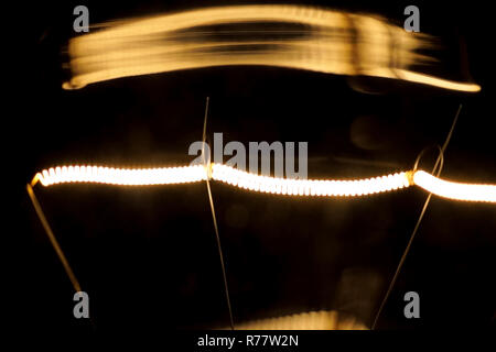 Tungsten filament in an incandescent lamp, macro photo. Stock Photo