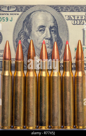 bullets close-up lie on the bills of 100 dollars. Concept of copy space currency and national defense Stock Photo