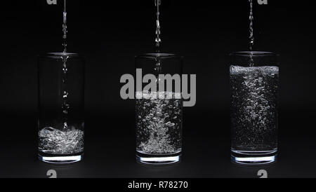 Empty, half full and full glass water isolated on black background Stock Photo