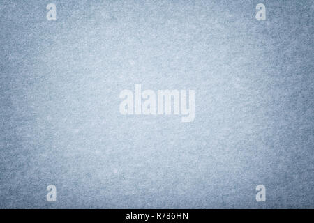 Light blue matte background of suede fabric, closeup. Velvet texture of seamless sky woolen felt with vignette. Stock Photo