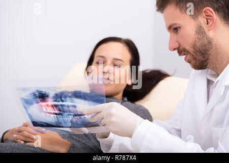 Close-up Of A Male Doctor Explaining X-ray To Female Patient In Clinic Stock Photo