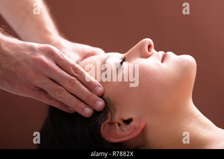 Close-up Of A Therapist Hand Massaging Young Woman's Head Stock Photo