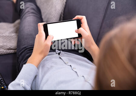 Close-up Of A Girl Using Smartphone With Blank White Screen Stock Photo