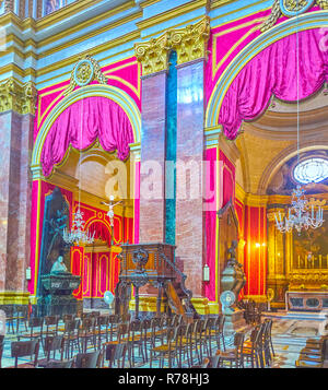 MDINA, MALTA - JUNE 14, 2018: The arcades between nave and aisles decorated with marble pilasters and purple curtains, on June 14 in Mdina. Stock Photo