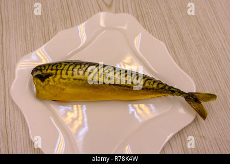 Hot smoked mackerel on plate on a white background Stock Photo