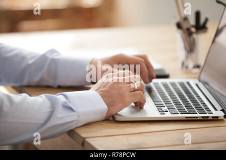 Close up of businessman using laptop browsing internet Stock Photo
