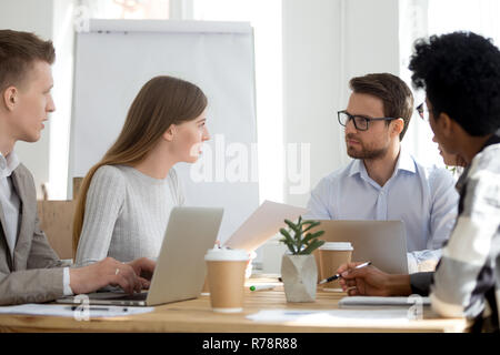 Diverse employees sit at meeting collaborating in office Stock Photo