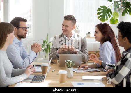 Diverse employees laugh when talking at office briefing Stock Photo