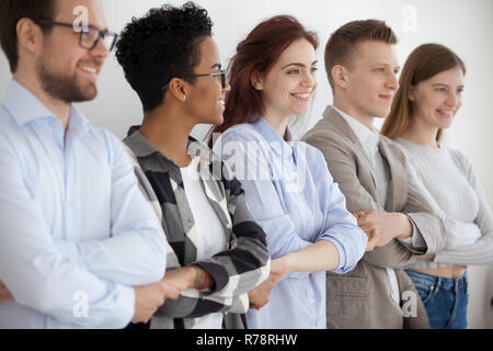 Diverse young people holding hands showing unity and teamwork Stock Photo