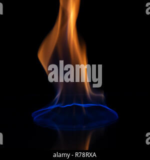 A burning flame glows brightly against a black background Stock Photo