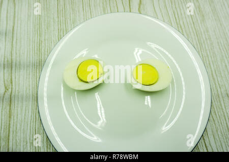 two halves of boiled eggs on wooden rustic background. the view from the top Stock Photo