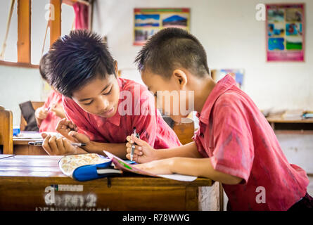 BALI, INDONESIA - APRIL 25, 2018: Young happy pupils wearing balinese school outfits studying at primary school on Bali island, Indonesia Stock Photo