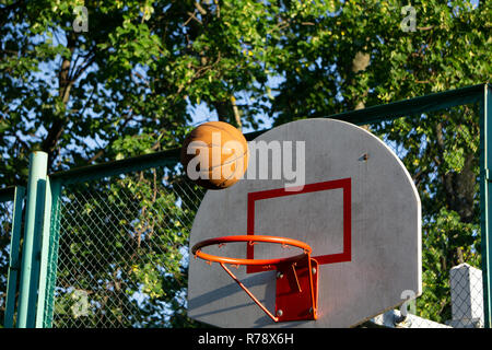 Motion basketball in air over hoop victory win Stock Photo