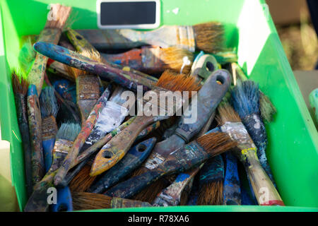 ARTIST's POUCH OF PAINT BRUSHES. Rustic painter s brushes of various shapes and sizes in an old leather pouch attached to one side of a table Stock Photo