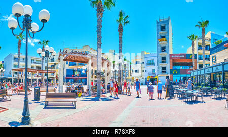 BUGIBBA, MALTA - JUNE 14, 2018: The holidaymakers choose the restaurant in Bay Square - the center of resort's tourist life, on June 14 in Bugibba. Stock Photo