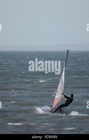 A lone windsurfer on fairly rough seas on UK waters Stock Photo