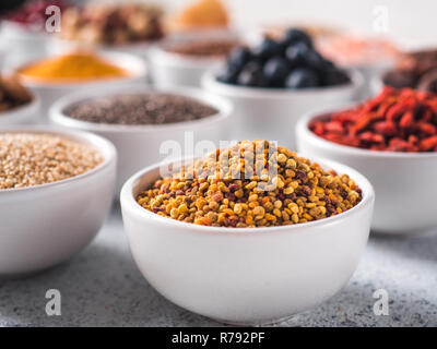 Bee pollen in small white bowl and other superfoods Stock Photo