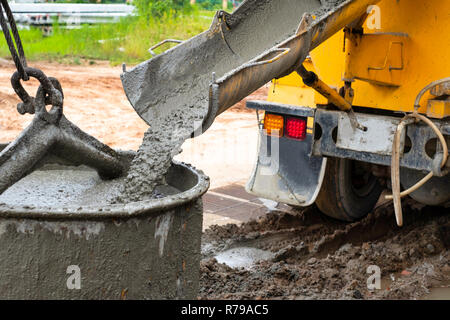 Pouring cement down from the cement mixer truck in construction site Stock Photo