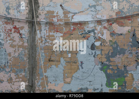 Old color brick wall with expressive spots of blue, beige, gray, lilac, green. Unreproducible picture. Renovation concept. Stock Photo