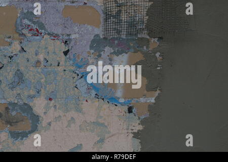 Old color vintage stone wall with grey new plastered cement concrete wall.  Renovation concept. Process Stock Photo