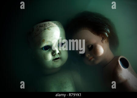 Creepy dolls in dark dirty water