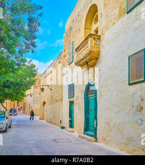 MDINA, MALTA - JUNE 14, 2018: Walking along warrow streets of old fortress and overlooking the medieval European architecture, on June 14 in Mdina. Stock Photo