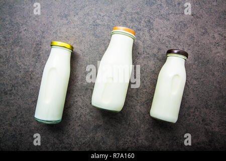 Milk bottle on dark stone background. Top view with copy space. Stock Photo