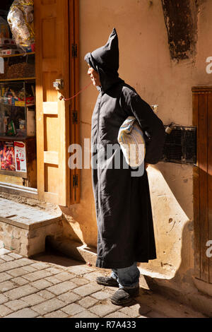 Morocco, Fes, Fes el Bali, Medina, Talaa Kebira, man in traditional djellaba cost in sunshine Stock Photo