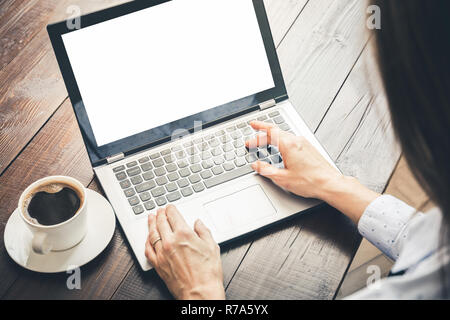Woman typing and searching by laptop in office. Space in screen for text. Stock Photo