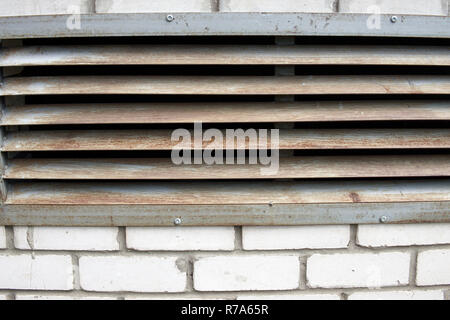 A brick wall with a rusty iron grille Stock Photo