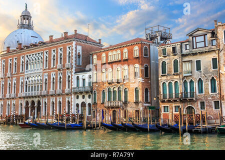 Gondolas of Venice in front of medieval palaces and the dome of  Stock Photo