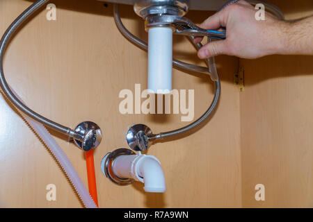 Plumber standing of washbasin writing of plumber repairing drain Stock Photo