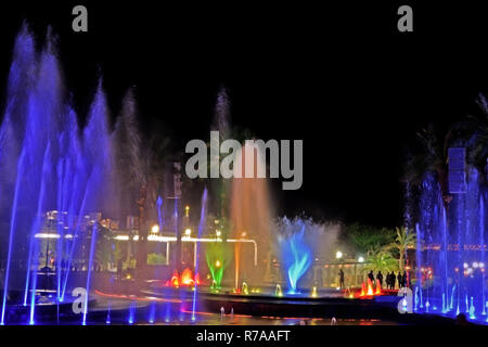 A glowing musical fountain at night. Splashes of colored water. Stock Photo