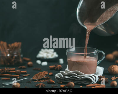 Pouring tasty cocoa drink into mug on table Stock Photo