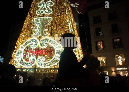 Malaga, Spain. 8th Dec, 2018. A boy is seen on his father's shoulders walking on the street during the christmas season at Plaza de la Constitucion square. Credit: Jesus Merida/SOPA Images/ZUMA Wire/Alamy Live News Stock Photo