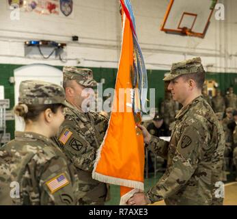 U.S. Army Maj. Ian Seagriff accepts the battalion colors from Brig. Gen. Michel Natali, commander of the 53rd Troop Command as he assumes command of the 101st Expeditionary Signal Battalion, New York Army National Guard, from outgoing commander Lt. Col. Diane Armbruster at the Police Athletic League Center, Yonkers, N.Y., April 9, 2017. Stock Photo