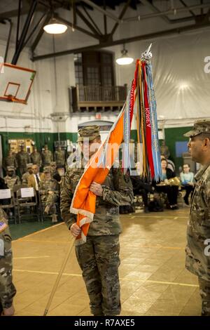 U.S. Army Maj. Ian Seagriff holds the battalion colors as he assumes command of the 101st Expeditionary Signal Battalion, New York Army National Guard, from outgoing commander Lt. Col. Diane Armbruster at the Police Athletic League Center, Yonkers, N.Y., April 9, 2017. Stock Photo